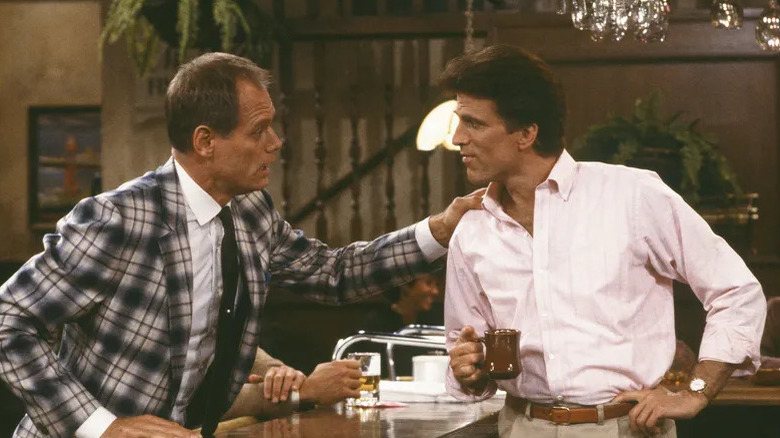 Fred Dryer puts a hand on Ted Danson's shoulder