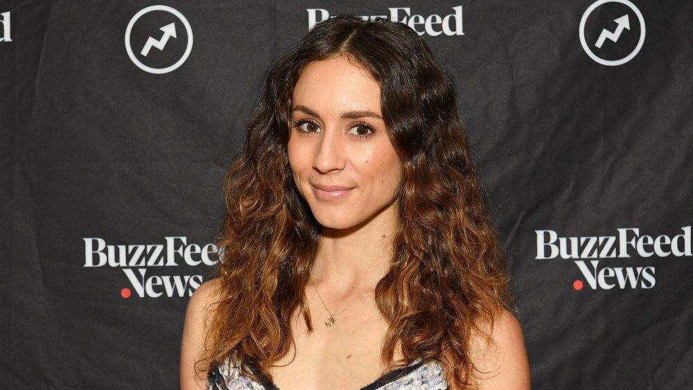 Troian Bellasario with wavy hair on the red carpet at a BuzzFeed event in 2019