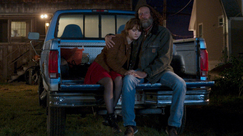 Emilia Jones and Troy Kotsur sit on a car