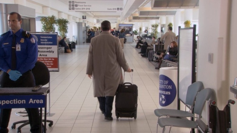 Michael back to camera rolling suitcase