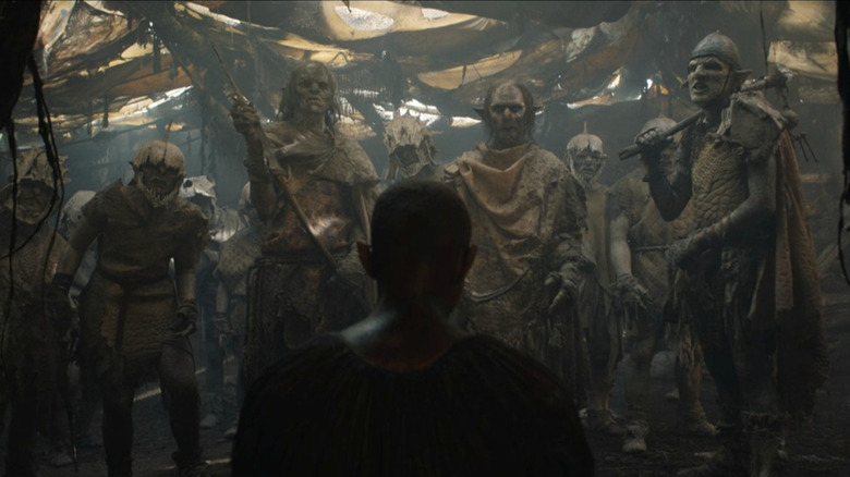 A captured Arondir faces a line of Orcs under cover