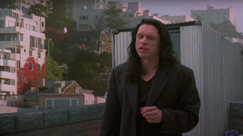 Tommy Wiseau standing on rooftop