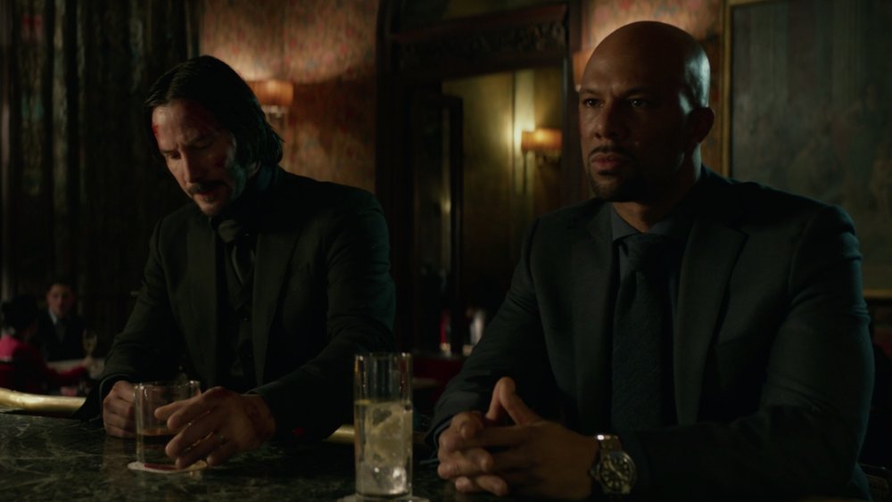 John Wick and Cassian sit at the Continental bar, minutes after trying to kill each other