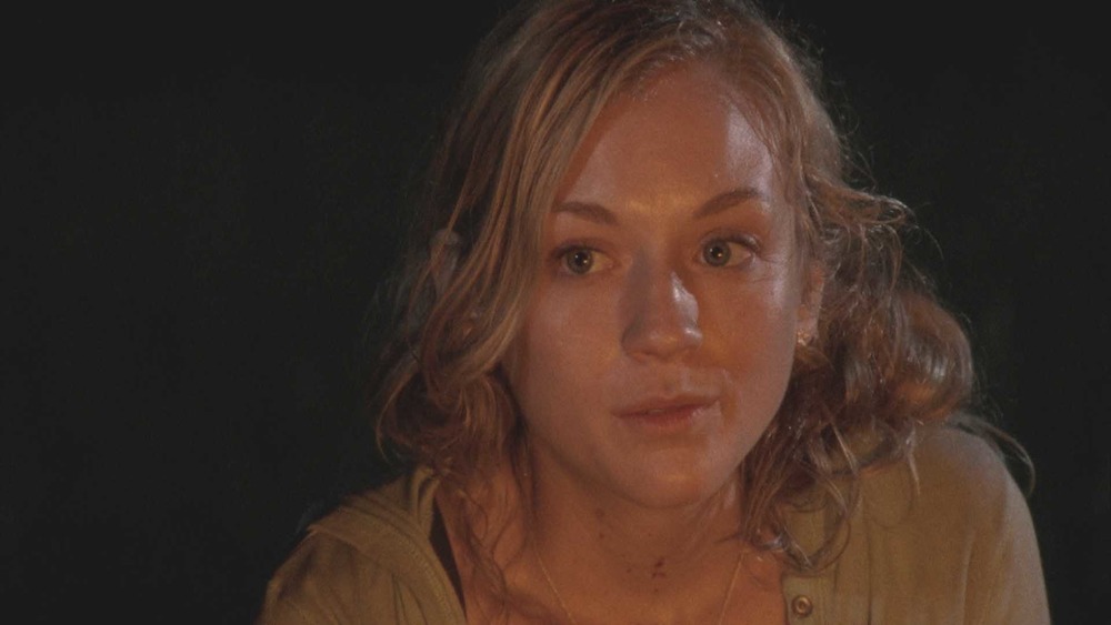 Beth Greene sits at a fire.