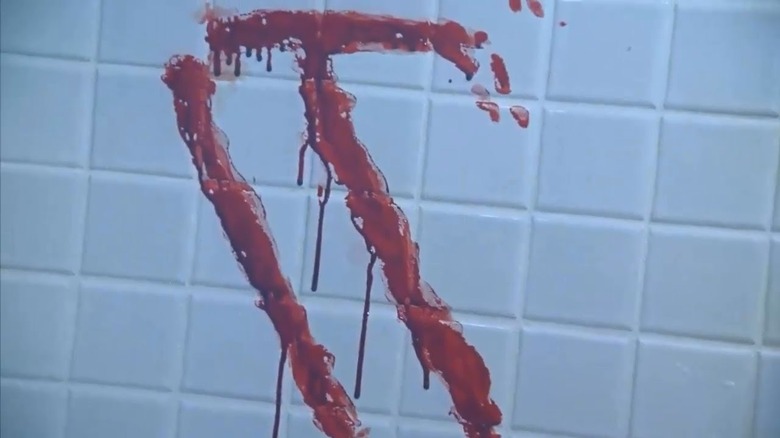 The word "IT" written in blood