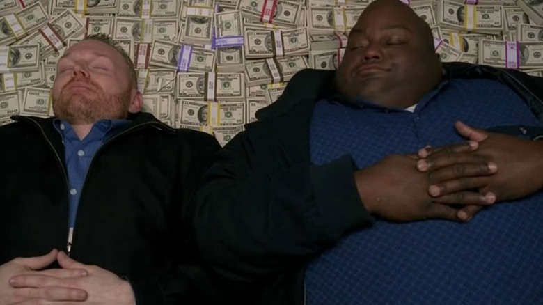 Huell and Kuby lay on top of a pile of money