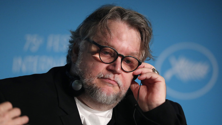 Del Toro listening to head phone during press conference