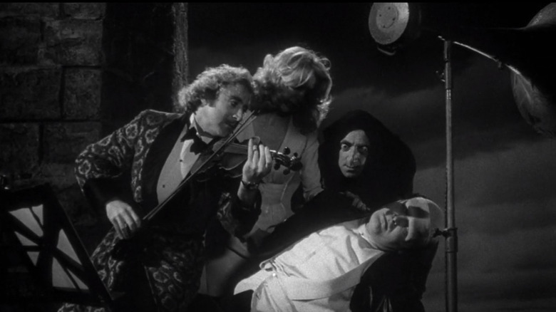 Cast of Young Frankenstein holding the monster