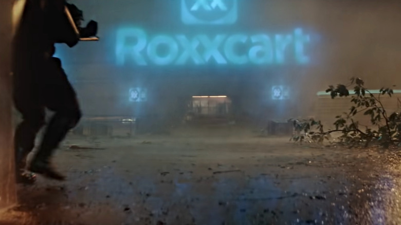 Glowing blue Roxxcart sign in rainstorm