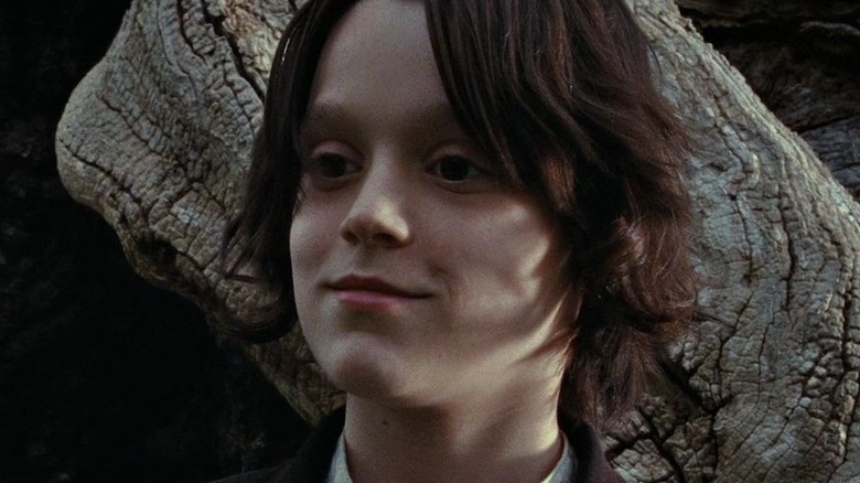 Young Snape smiling beside a tree