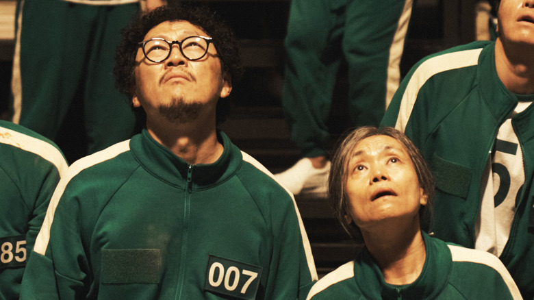 Park Yong-sik and Jang Geum-ja look up in Squid Game (2024)