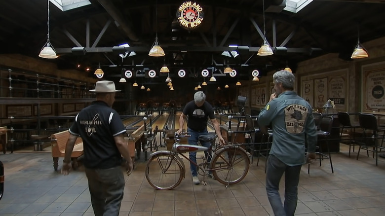 Mike and Robbie Wolfe inspect a Schwinn Aerocycle inside a bowling alley