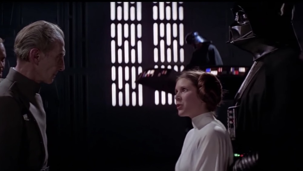 Princess Leia (Carrie Fisher) is brought before Moff Tarkin (Peter Cushing) in Star Wars: A New Hope