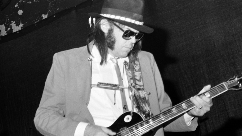 Neil Young playing guitar on stage