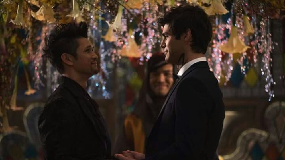 Magnus and Alec hold hands at their wedding on Shadowhunters