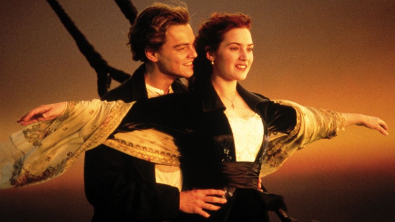 Leonardo DiCaprio and Kate Winslet, arms outstretched, stand on the bow of the Titanic