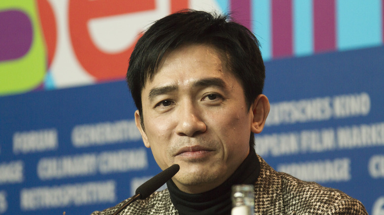 Tony Leung sitting in front of microphone