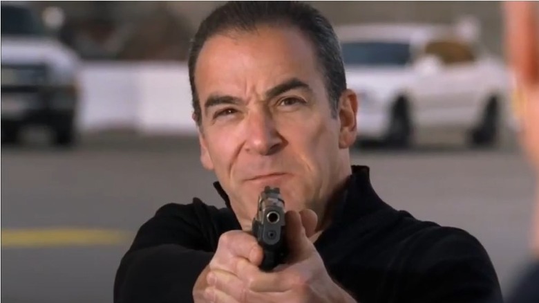 Mandy Patinkin pointing a gun