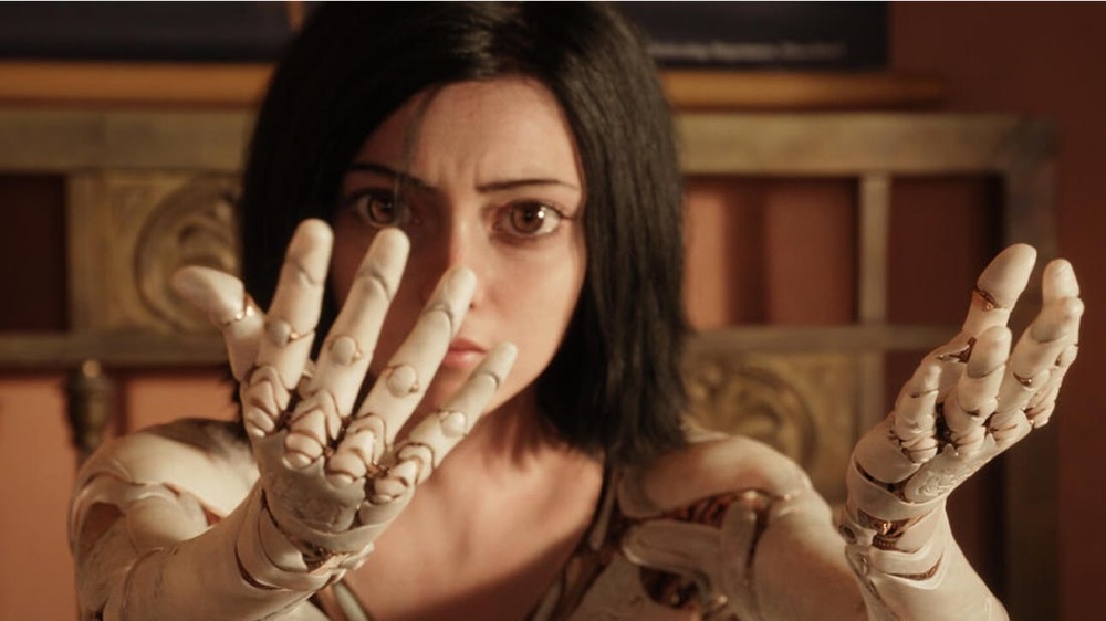 Alita inspecting her robotic arms