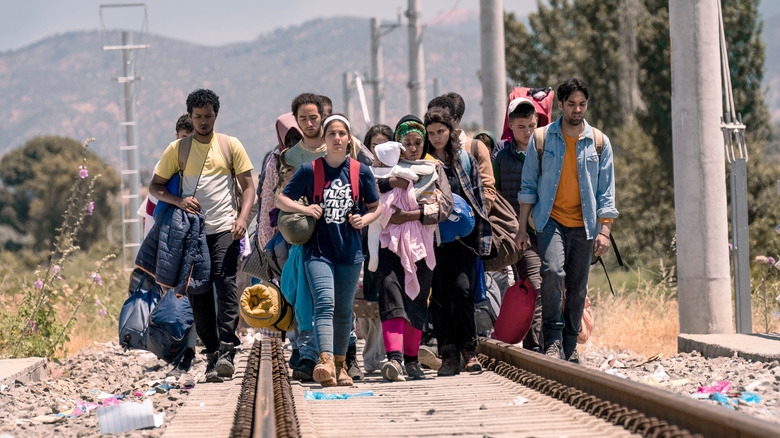 Refugees walking along train tracks