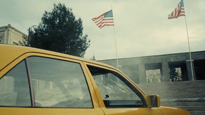 Damaged taxi in front of American flags