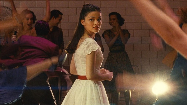 Maria looking over her shoulder in front of a beam of light in West Side Story