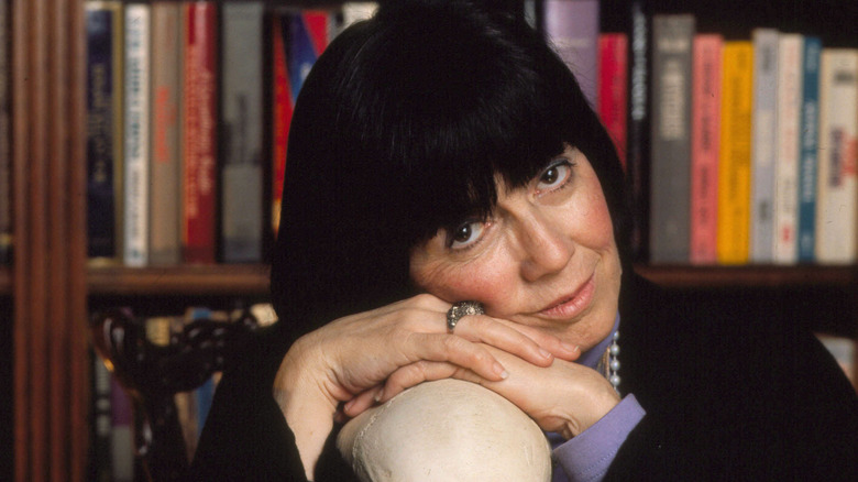 Anne Rice leaning on the top of a skull