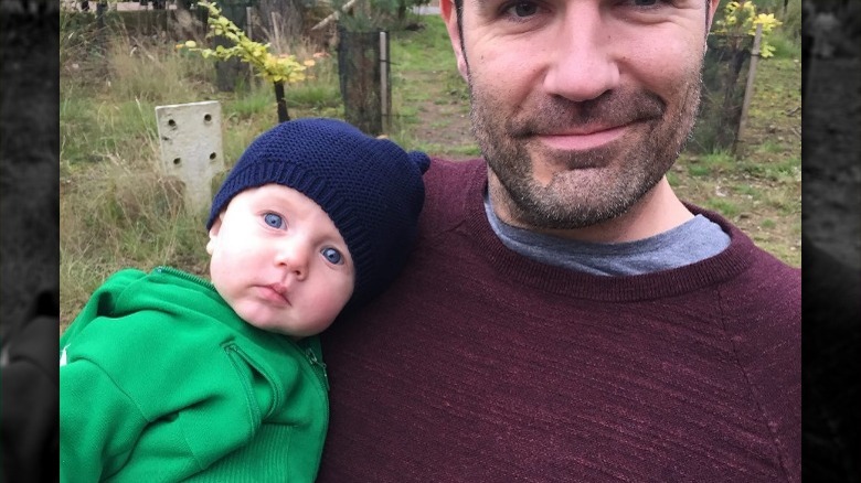 Rob Delaney holds his infant son