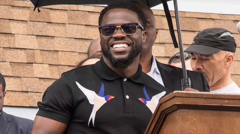 Kevin Hart smiling in sunglasses at his mural dedication ceremony in Philadelphia in 2017