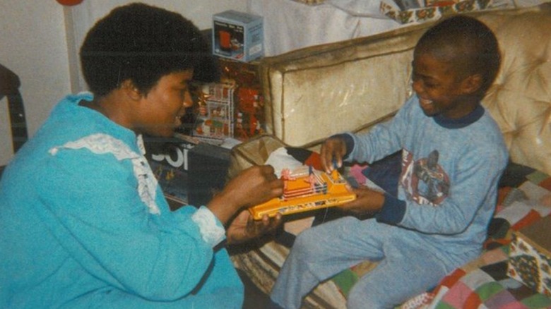 Nancy Hart helping a young Kevin Hart open a gift on Christmas