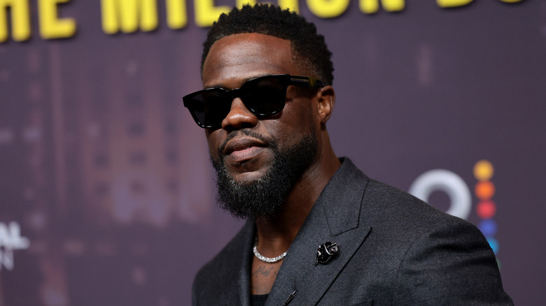 Kevin Hart in sunglasses at an event in 2024 with purple background