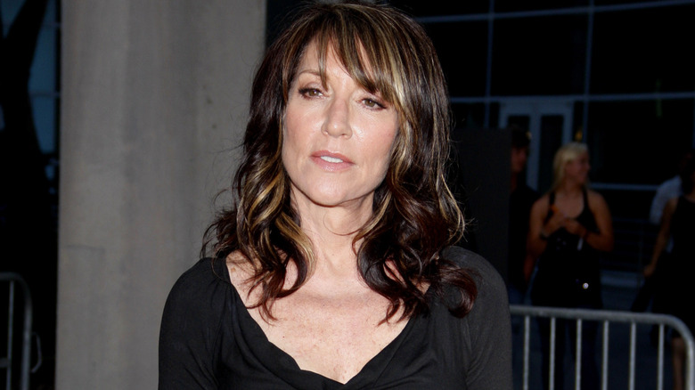 Katey Sagal wearing black standing outside building looking serious