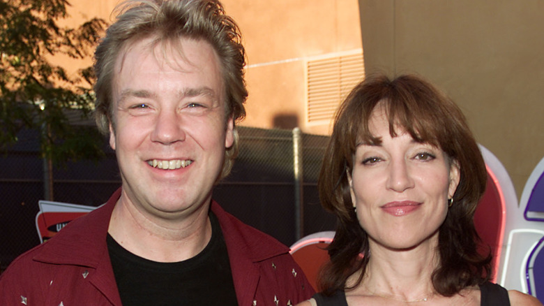 Jack White wearing red jacket and black shirt smiling next to Katey Sagal