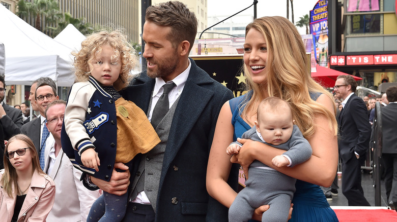 Ryan Reynolds and Blake Lively holding their kids