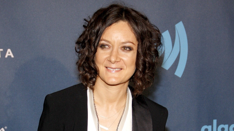 Sara Gilbert smiling blue background