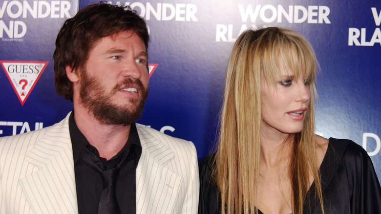 Val Kilmer and Daryl Hannah facing right at an event in front of a purple background