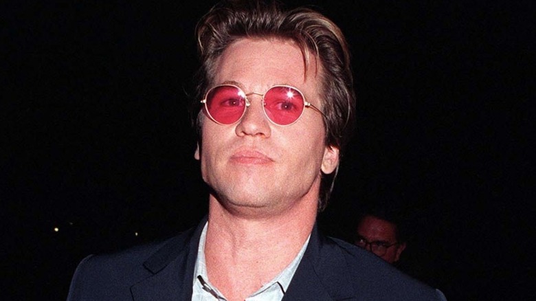 Val Kilmer at an event wearing red glasses