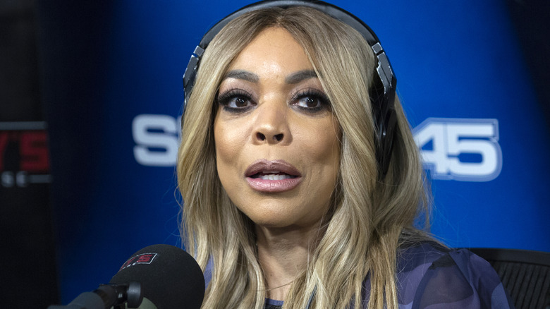 Wendy Williams wearing headphones and talking on the radio