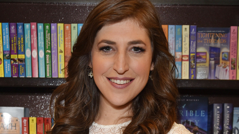 Mayim Bialik posing near books