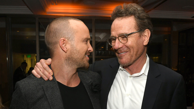 Aaron Paul smiling with Bryan Cranston at an event