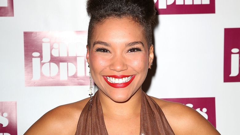 Emmy Raver-Lampman smiling with red lipstick