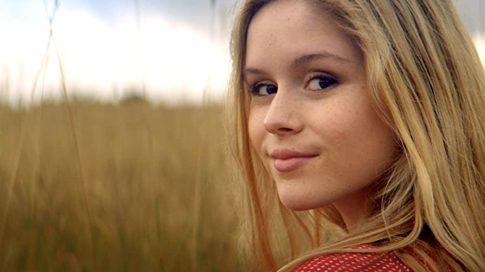 Erin Moriarty as Kelly smiling in field