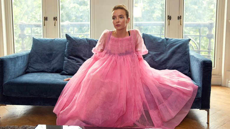 Villanelle sitting on couch in big pink dress