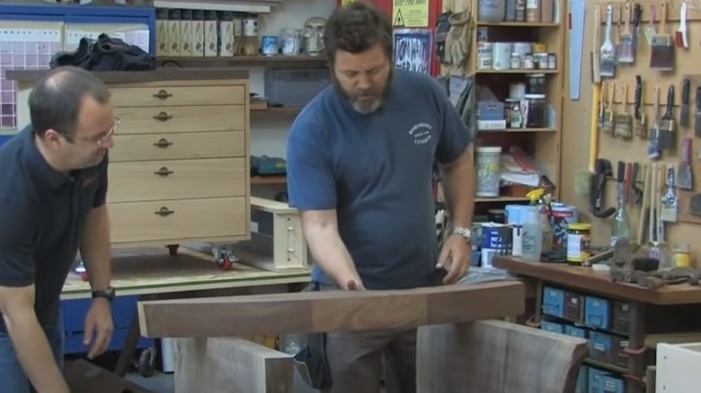 Nick Offerman examines an object in his workshop