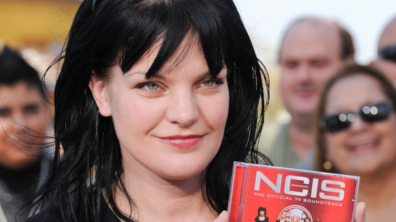 Pauley Perrette holding an NCIS soundtrack cd album