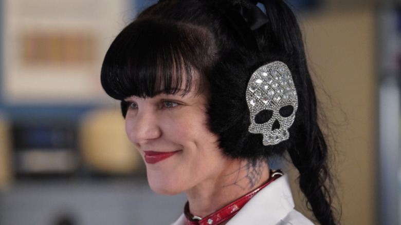 Abby Sciuto wearing skull earmuffs smiling