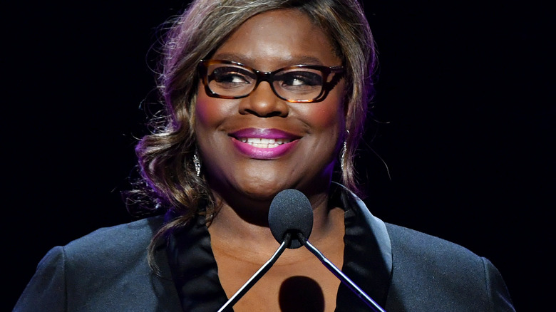 Retta standing at a podium