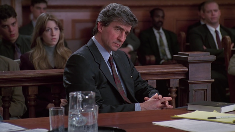 Jack McCoy listens intently from behind a desk in a courtroom