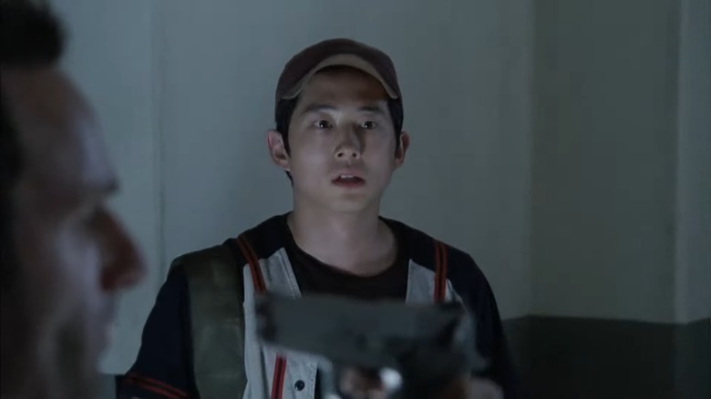 Glenn Rhee looks on as a gun is pointed at Rick Grimes