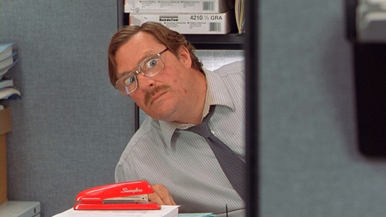 Milton staring out from behind his desk